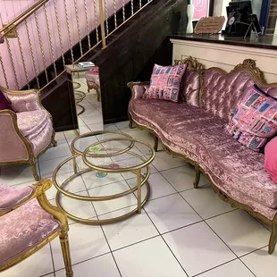 a pink couch and chairs