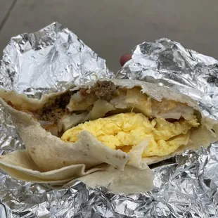a breakfast burrito wrapped in aluminum foil