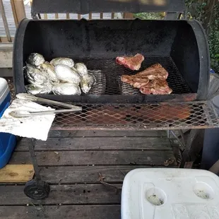 a grill with steaks and oysters on it