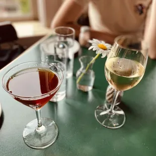 a woman sitting at a table with a glass of wine