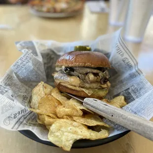 Mushroom Swiss sandwich served with potato chips.