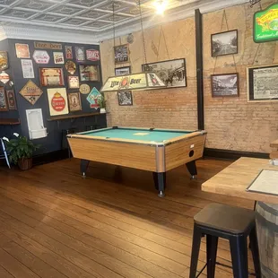 Pool table with cues and chalk.