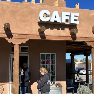 a woman standing outside of a cafe