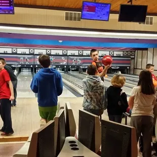 a group of people standing in a bowling alley