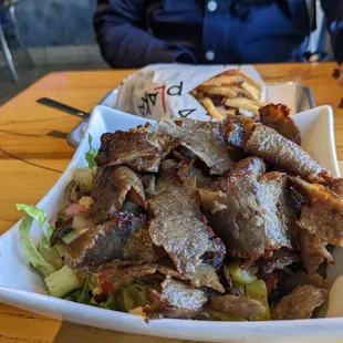 Salad bowl with Chicago gyro meat. Background: Plaka Gyro