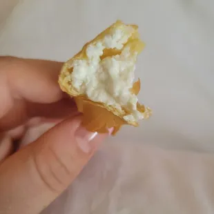 a hand holding a half eaten pastry