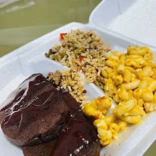 a plate of meat, rice, and corn