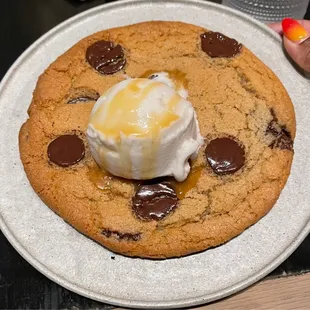 Huge chocolate chip cookie served warm with coconut ice cream and caramel drizzle. OMG Love this dessert!