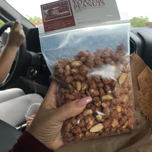 a hand holding a bag of nuts