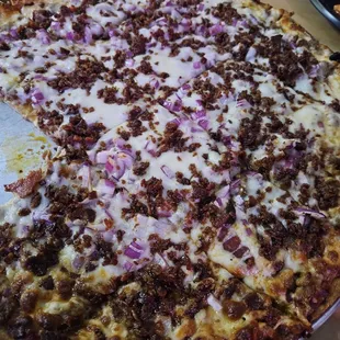 a large pizza with onions and meat