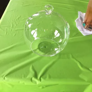 empty glass globe sitting on the cheery green tablecloth