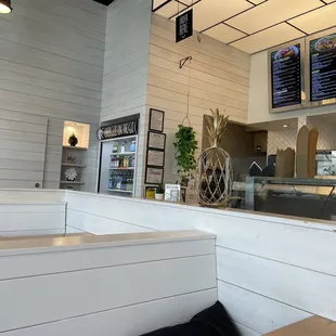 a restaurant counter with menus on the wall
