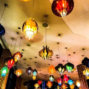 a variety of colorful lamps hanging from the ceiling
