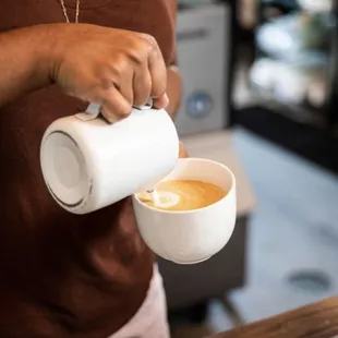 a woman pouring a cup of coffee