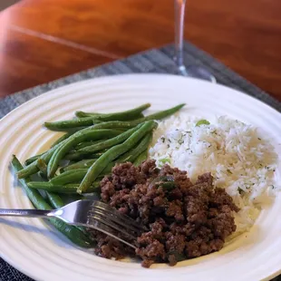 a plate of food with rice, beans, and meat
