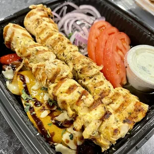 Takeout order of chicken kabob and grilled vegetables