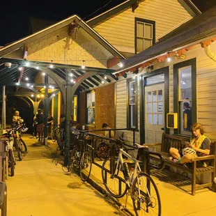 a group of people sitting on benches outside of a restaurant