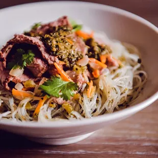 a bowl of noodles with meat and vegetables
