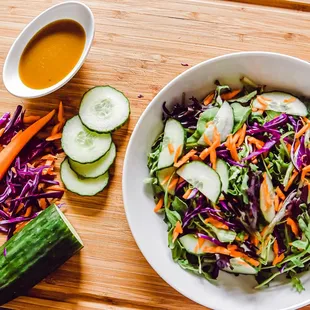 a bowl of salad with carrots and cucumbers
