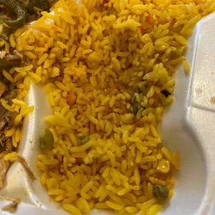 a white styrofoam container filled with rice and vegetables