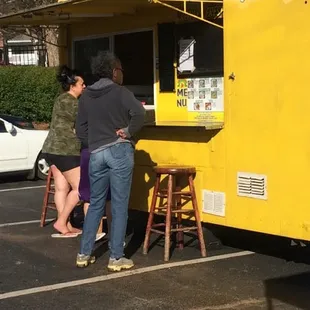 a yellow food truck parked in a parking lot