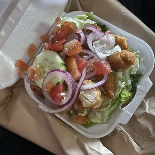 a salad in a styrofoam container