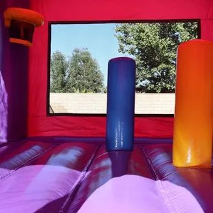 Inside our 3 in 1 Pink/Purple Castle Bouncer - With a basketball hoop and obstacle poles for extra fun!