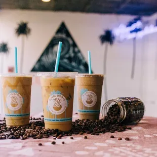 three cups of iced coffee on a table