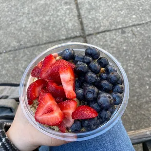 strawberries and blueberries in a plastic bowl