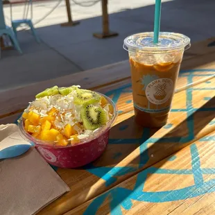 Pitaya bowl with mango, kiwi , granola, coconut and honey. Along with an iced coffee!