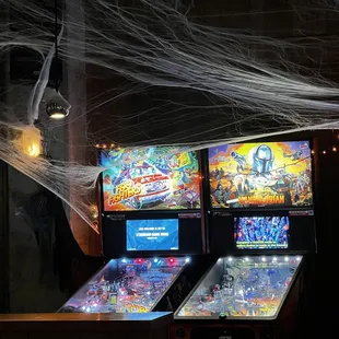 two pinball machines and a spider web