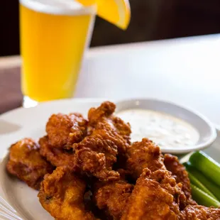 House hot wings served with celery sticks, ranch dressing, and a cold beer