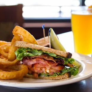 BLT on wheat bread, served with onion rings and a pickle spear