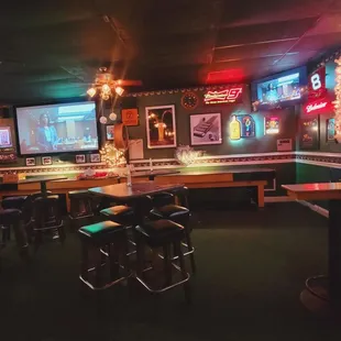 a bar with a lot of seating and neon signs