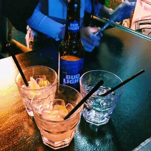 two glasses of water and a bottle of beer