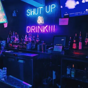 a neon sign that says shut up and drink