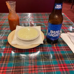 a bowl of soup and a bottle of bud light