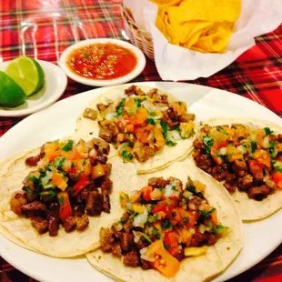 Carne asada tacos with salsa and chips.