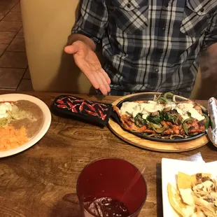 a man sitting at a table with plates of food