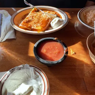 Cheese enchiladas, side of sour cream (with already a spoonful eagerly taken out by us), and salsa (we&apos;re messy)
