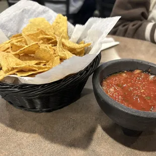 a bowl of chips and a bowl of salsa