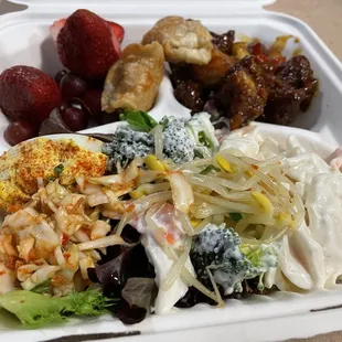 Deviled egg, mandu, kimchi, crab meat salad, orange chicken, and fruit