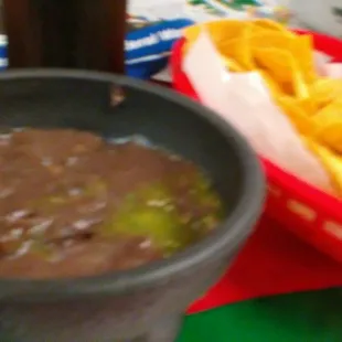 a bowl of black bean soup and a bowl of tortillas