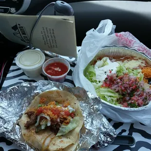 a taco and a salad on a table in a car