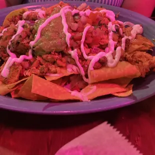 House special nachos. Chicken and Chorizo. Melted cheese and beans are below the other toppings.