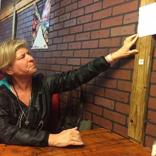 My friend reading the Spanish menu hanging on the wall