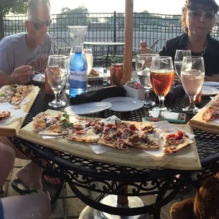 a group of people sitting around a table eating pizza