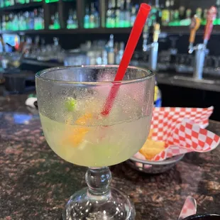 a drink in a glass with a straw and a red straw