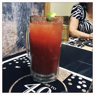 a bloody drink with a lime garnish