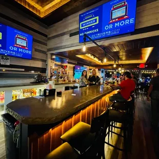 people sitting at the bar and watching televisions